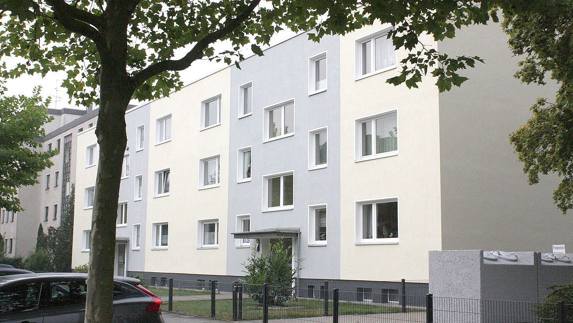 Saniertes Mehrfamilienwohnhaus mit grau-weiß abgesetzter Fassade