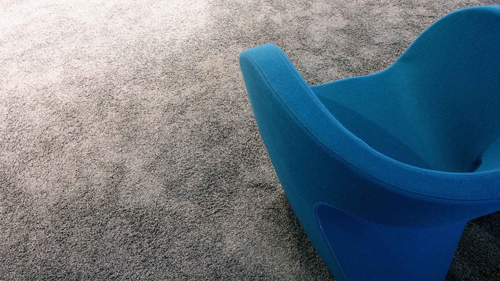 Blauer Couch-Sessel auf grauem Teppichboden